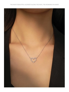 Detail of a sterling silver heart pendant necklace with purple zircons worn by a model