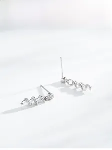 Detailed view of silver spiral earrings featuring single round-cut zircon stone inlays