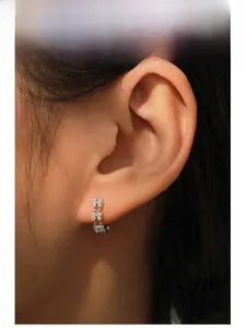 Close-up of 925 sterling silver hoop earrings with marquise-cut zircons on model ear