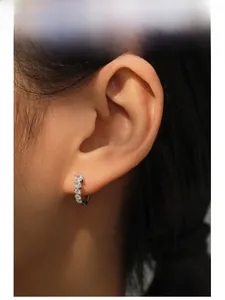 Close-up of S925 sterling silver hoop earrings with zircon stones on a model's ear