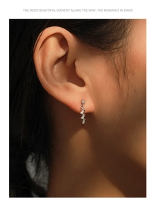Detail of silver spiral drop earrings featuring micro-pave baguette and round crystals