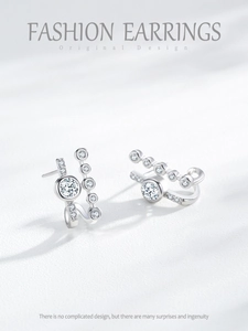 Detail of silver S925 earrings with geometric curves and sparkling zircon stones