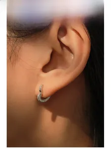 Close-up of S925 sterling silver heart-shaped earring with pavé zircon stones on ear