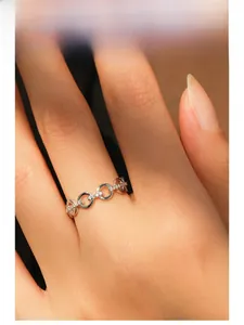 Close-up of a silver 925 chain ring with pavé-set diamonds on a model's finger