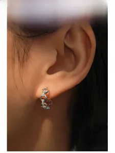 Close-up of S925 silver chain link hoop earrings with white zircon on a model