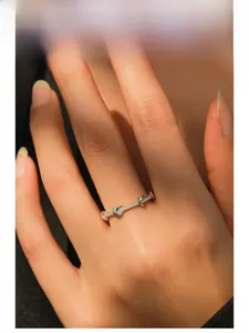 Detail of twisted silver ring with micro-pave diamonds on model's finger