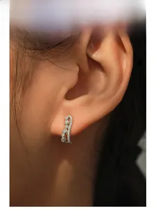 Close-up of S925 sterling silver wavy stud earrings with sparkling pavé cubic zirconia