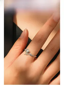 Detailed close-up of a silver rose ring with sparkling zircon and twig texture on model