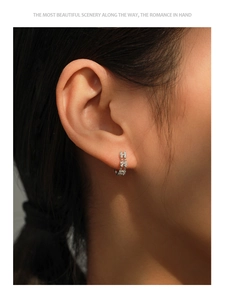 Macro detail of 925 silver hoop earrings with double-row zircon pavé on model's ear
