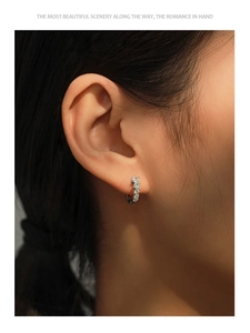 Close-up of S925 silver hoop earrings with five sparkling cubic zirconia on a model