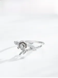 Detailed view of silver rose ring featuring realistic branch texture and tiny zircon