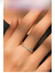 Close-up of S925 sterling silver crisscross ring with pavé diamonds on model hand