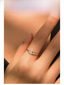 Detail of model wearing a twisted S925 sterling silver ring with micro-pave crystals