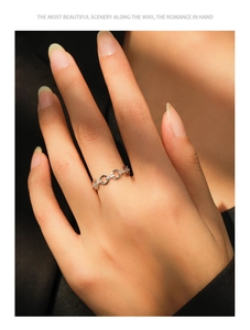 Macro detail of silver chain ring with pavé cubic zirconia diamonds on hand