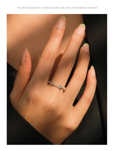 Detailed view of silver knot ring with pavé stones worn on a finger