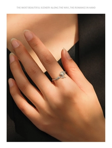 Detailed view of S925 silver rose ring with vine texture on finger in warm light