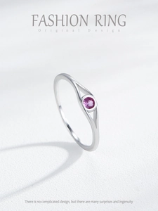 Macro shot of silver ring with pink round stone and unique eye-shaped hollow bezel