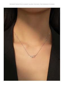 Detailed view of silver angel wings necklace with micro-pave diamonds on a model