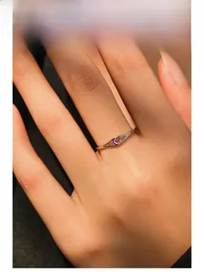 Macro detail of S925 sterling silver ring featuring a round rose pink gemstone on finger