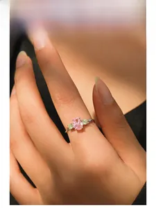 Close-up of a three-stone S925 silver ring featuring an oval pink gemstone on finger