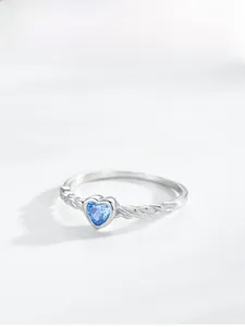 Detailed view of the twisted S925 silver band and the blue heart gemstone setting