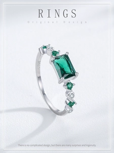 Macro detail of S925 hallmark on silver ring band with emerald-cut green gemstone