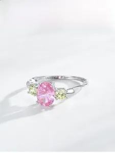 Macro detail of S925 silver ring featuring a pink oval stone and three-stone setting