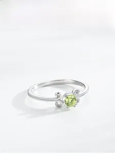 Detail von S925 Silberring mit apfelgrünem Edelstein und hohlem Schnörkeldesign