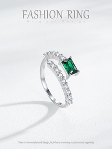 Macro detail of S925 sterling silver ring with square green gemstone and side diamonds