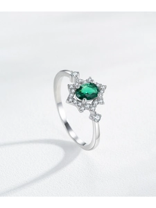 Close-up of S925 silver ring featuring an oval emerald and star-shaped setting
