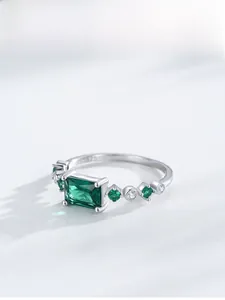 Detailed close-up of S925 sterling silver stamp and emerald-cut green gemstone ring