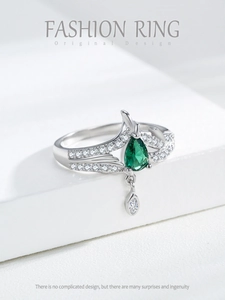 Close-up of silver crown ring with pear-shaped green gemstone and marquise diamond charm