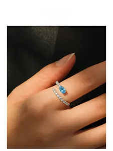 Detail view of S925 sterling silver mermaid tear ring with blue gemstone on model hand