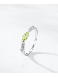 Macro view of marquise-cut green gem on S925 silver ring with feather engravings