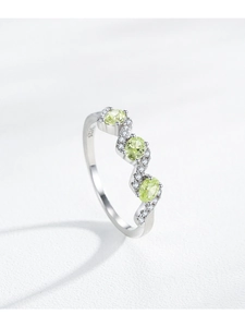 Macro shot of S925 sterling silver wavy ring featuring green oval zircons and tiny diamonds