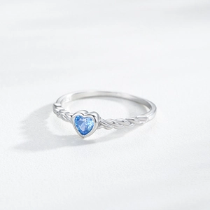 Elegant S925 silver ring featuring heart-shaped blue stone and braided band design