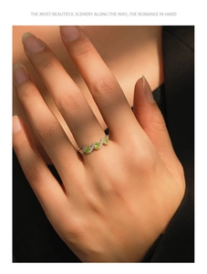 Macro shot of S925 silver ring with three green zircons and pavé diamonds in wave design