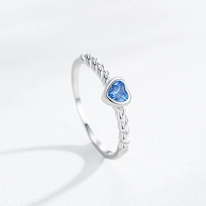 Romantic S925 sterling silver ring featuring a blue heart-shaped gem and twisted band