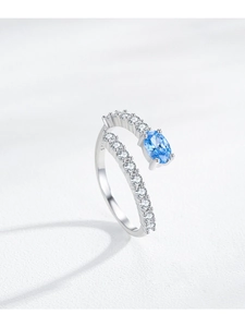 Macro detail of S925 sterling silver ring with oval blue gemstone and side pave zircons