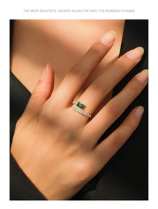 Macro detail of adjustable S925 silver ring with emerald-cut green stone and pavé diamonds