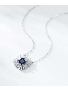 Gros plan du pendentif fleur avec saphir bleu profond et diamants rayonnants