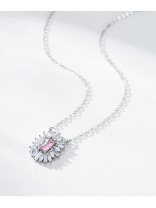 Macro shot of silver flower pendant featuring a pink rectangular gemstone and diamonds