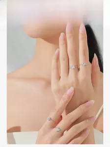 Detail of silver S925 heart chain rings styled as a layered set on a model's hand