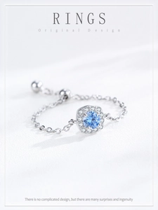 Macro shot of silver chain ring with blue zircon center stone and adjustable slider