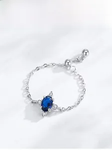 Detail of S925 silver chain ring featuring an oval blue sapphire and pavé diamonds