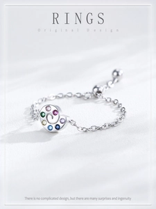 Detail of sterling silver snail chain ring featuring colorful round zircon stones
