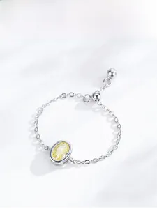 Macro detail of S925 sterling silver chain ring with oval yellow zircon and slider