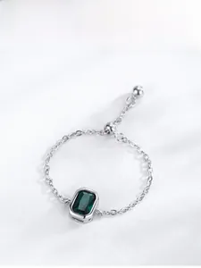 Detail of adjustable S925 silver ring with emerald cut green gemstone and chain link