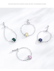 Detail of S925 sterling silver adjustable chain rings with emerald and zircon gemstones