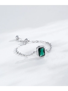 Macro detail of S925 sterling silver chain ring with emerald cut green gemstone